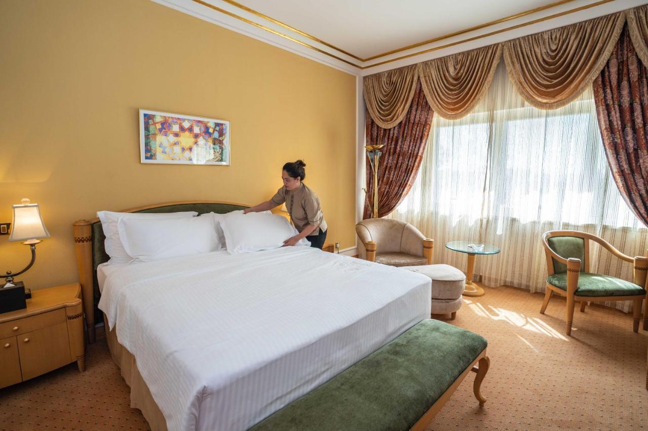 Officers Club & Hotel Abu Dabi Exterior foto A chambermaid making a bed in a hotel room